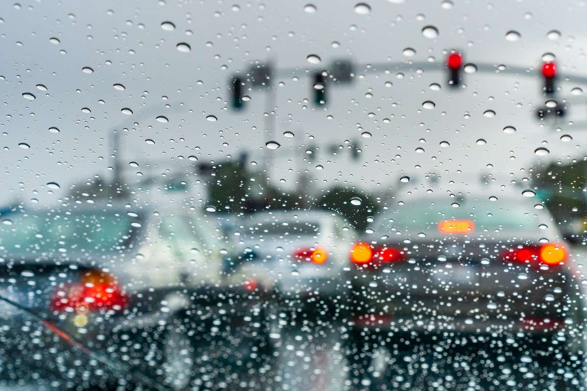 Cars stopped at an intersection in the rain