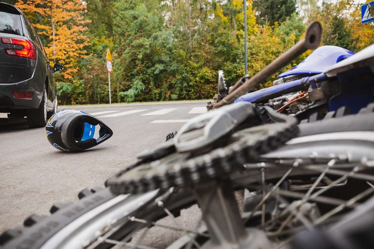 A motorcycle and helmet on the ground after a crash